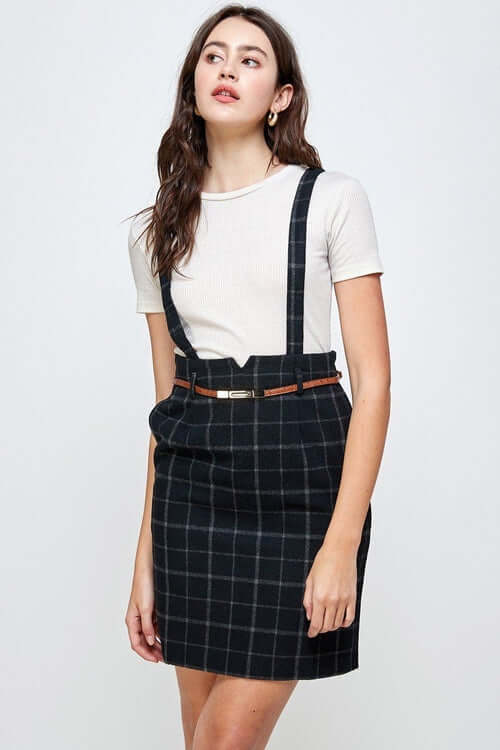 Plaid Suspender Skirt with Belt Detail worn over a casual top, showcasing chic and modern fashion style.