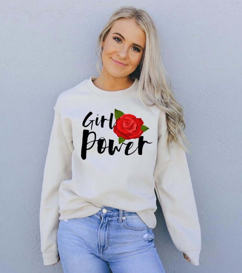 Smiling model wearing a Girl Power Sweatshirt featuring a rose design, styled in casual fashion against a gray background.