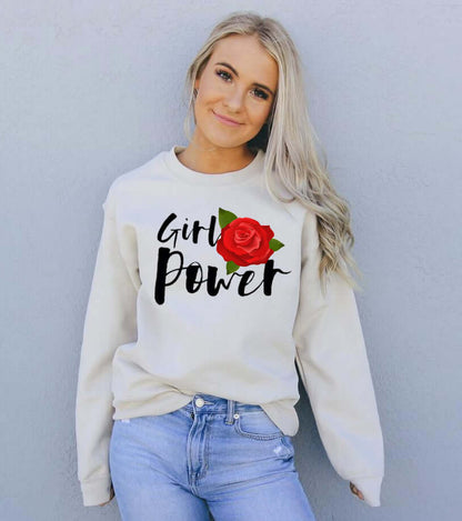 Smiling model wearing a Girl Power Sweatshirt featuring a rose design, styled in casual fashion against a gray background.
